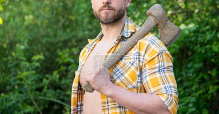 Photo for Cropped view of rancher with axe outdoor. photo of rancher with axe. rancher with axe. rancher with axe wearing checkered shirt. - Royalty Free Image