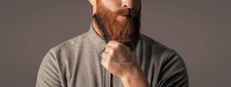Photo for Cropped view of man has beard in studio. man combing beard with haircomb. combing and styling. bearded man combing beard isolated on grey background. man with beard combing hair. - Royalty Free Image