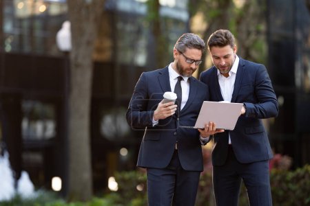 Photo for Photo of businessmen trading online, banner. two businessmen trading online. businessmen trading online outdoor. businessmen trading online with laptop. - Royalty Free Image