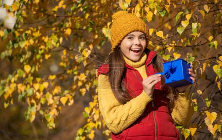 Photo for Surprised teen girl with present box in autumn. - Royalty Free Image