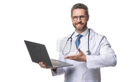 Photo for Smiling doctor offering emedicine in studio. doctor presenting emedicine on background. photo of emedicine and doctor man with laptop. doctor promoting emedicine isolated on white. - Royalty Free Image