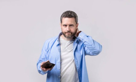 Photo for Concerned moneyless man with wallet in studio. moneyless man with wallet at hand. photo of moneyless man with wallet. moneyless man with wallet isolated on studio background. - Royalty Free Image