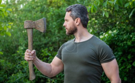 Photo for Masculine guy in profile with axe outdoor. photo of masculine guy with axe. masculine guy with axe. bearded masculine guy with axe. - Royalty Free Image
