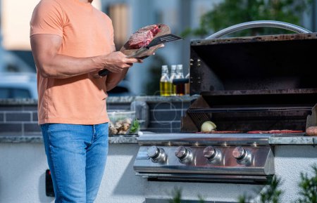 Photo for Barbecue man grilling meat onglet steak at outdoor backyard grill bbq, copy space. - Royalty Free Image
