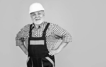 Photo for Happy senior man builder in hard hat on yellow background. - Royalty Free Image