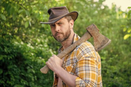 Photo for Bearded rancher with axe wearing checkered shirt. rancher with axe outdoor. photo of rancher with axe. rancher with axe. - Royalty Free Image