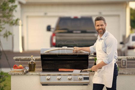 Photo for Man barbecuing trout fillet, copy space banner. man barbecuing trout fillet outdoor. man barbecuing trout fillet at backyard. photo of man barbecuing trout fillet on grill. - Royalty Free Image