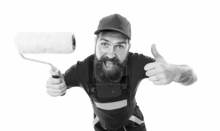 Photo for Happy bearded man painter with paintroller in studio. man painter with paintroller isolated on white background. man painter with paintroller show thumb up. man painter with paintroller in uniform. - Royalty Free Image