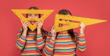Photo for Happy school students hold math tool of triangle. - Royalty Free Image