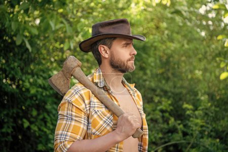 Photo for Bearded cowboy with axe. cowboy with axe wearing checkered shirt. cowboy with axe outdoor. photo of cowboy with axe. - Royalty Free Image