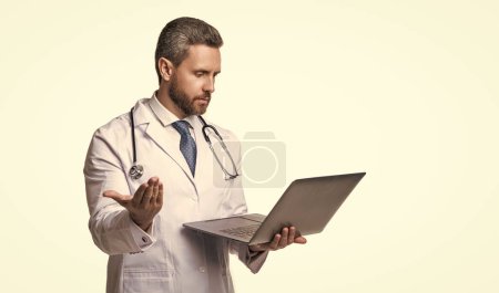Photo for Doctor man with laptop, copy space. doctor promoting ehealth isolated on white. doctor offering ehealth in studio. doctor presenting ehealth on background. - Royalty Free Image