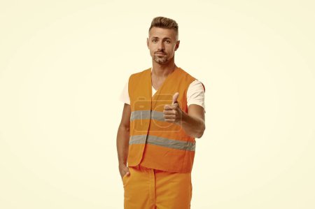 Photo for Man builder on background, thumb up. photo of man builder wearing reflective vest. man builder isolated on white. man builder in white studio. - Royalty Free Image