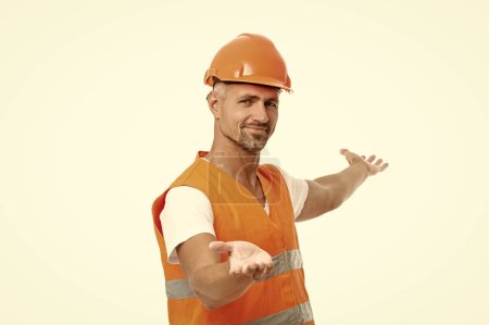 Photo for Man laborer in white studio, presenting product. man laborer on background. photo of man laborer wearing reflective vest. man laborer isolated on white. - Royalty Free Image
