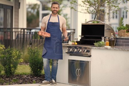 Photo for Full length of chef man cooking salmon on grill outdoor. grill salmon fish at man wear apron. photo of man with grill salmon. man cook salmon on grill. - Royalty Free Image