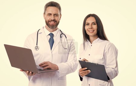 Photo for Happy doctor with internist noting ehealth. doctor and internist wear white coat and noting ehealth. internist and doctor with laptop and anamnesis. doctor and internist do ehealth noting - Royalty Free Image