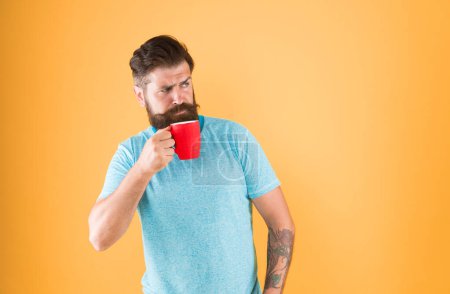 Photo for Morning habits lifestyle. Fanatic of coffee culture. Energy concept. Hipster barista yellow background. Coffee shop. Bearded man drink morning coffee. Tea time. Coffee with right proportion of milk. - Royalty Free Image