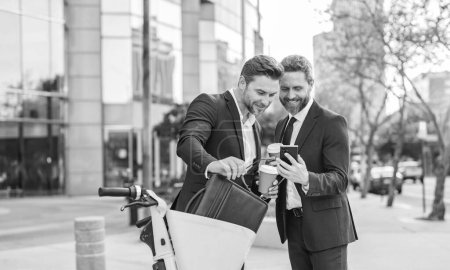Photo for Business colleagues with phone in the street, copy space. business colleagues with phone outdoor. business colleagues with phone in suit. photo of business colleagues with phone and coffee. - Royalty Free Image