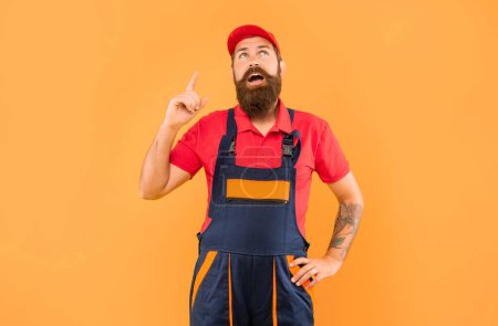 Photo for Inspired bearded man mechanic in work clothes on yellow background. - Royalty Free Image