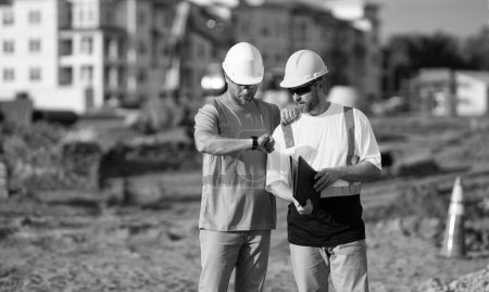 Téléchargez les photos : Contremaître de chantier et ingénieur civil à l'horaire de contrôle du travail. - en image libre de droit