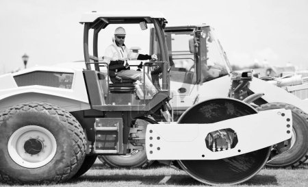 Photo for Man worker at construction machinery outdoor. man construction worker used vibratory roller. busy worker man on construction equipment. construction worker man drive heavy machinery for american road. - Royalty Free Image