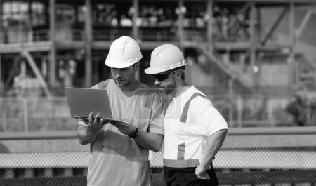 Photo for Concentrated supervisor men have construction project on laptop. photo of supervisor men with construction project. supervisor men with construction project. supervisor men discussing project - Royalty Free Image