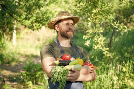 man in straw hat hold organic ripe vegetables.