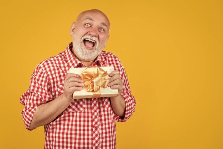 Photo for Surprised senior man with present box for retirement. - Royalty Free Image