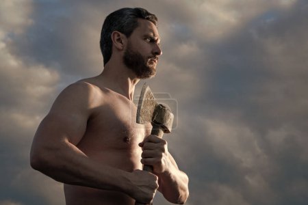 shirtless man with axe. athlete man hold ax. brutal man on sky background.