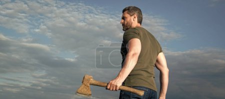 man with axe. woodsman man hold ax. brutal man on sky background.
