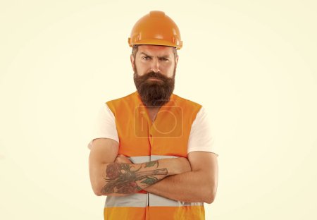 serious engineer isolated on white background. engineer man in uniform. bearded engineer in orange vest. studio shot of engineer wearing helmet.