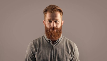 Irischer Mann. Bärtiger Mann mit rotem Bart und Schnurrbart. Seriöser unrasierter Mann isoliert auf grau.