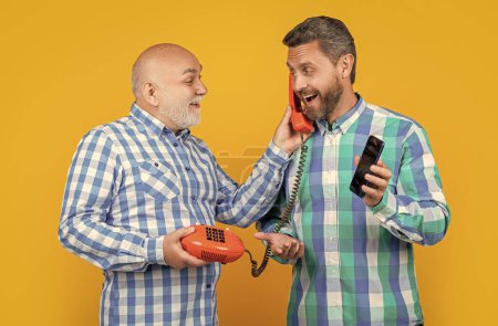 image of men with telephone contrast call. men with telephone contrast call isolated on yellow. men with telephone contrast call in studio. men with telephone contrast call on background.