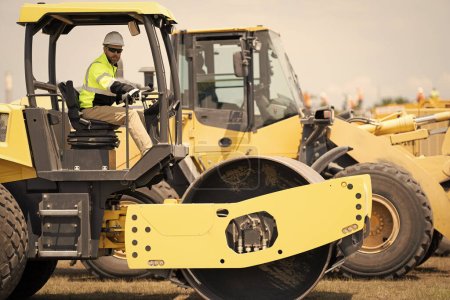 Photo for Busy worker man in construction equipment. construction worker drive heavy machinery for roadwork. man worker at construction machinery outdoor. A construction worker used vibratory road roller. - Royalty Free Image