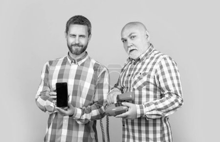 men with vs technology isolated on yellow. men with vs technology in studio. men with vs technology on background. photo of men with vs technology phone and telephone.