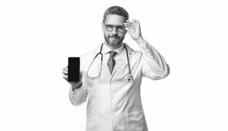 Photo for Smiling medical man show telehealth on background. photo of medical man show telehealth on phone screen. medical man show telehealth isolated on white. medical man show telehealth in studio. - Royalty Free Image