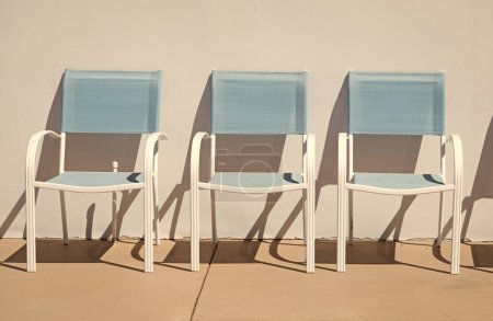 muebles de sillas de patio salón al aire libre para el verano en la pared soleada.