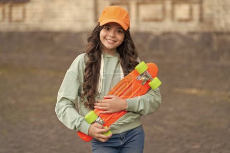 teen girl smile skater with skateboard outdoor. girl with penny board. hipster girl with longboard skate.