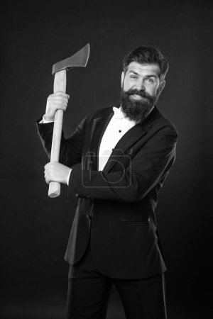Aggressive bearded man threatening with axe dark background, aggression.