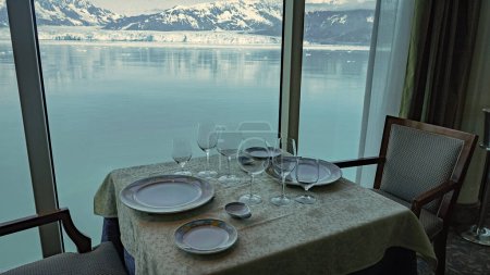 Hubbard Glacier restaurant served. Travel destination, no people. Restaurant interior with table set by panoramic window at scenic glacier bay nature. Empty mountain glacier restaurant in natural park