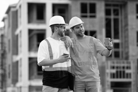 two engineer men at construction site wearing hardhat outdoor.