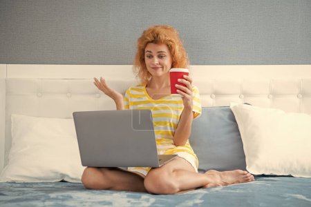 puzzled woman freelancer with coffee work at home on laptop. freelancer woman work at home. home work for freelancer. woman in bed with laptop.