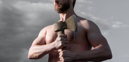 cropped view of shirtless man with axe. athlete man hold ax. brutal man on sky background.