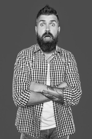 surprised bearded man wear checkered shirt on grey background.