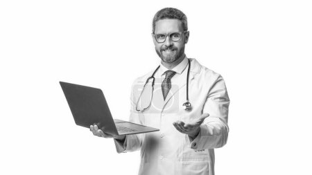 cheerful doctor promoting emedicine isolated on white. doctor offering emedicine in studio. doctor presenting emedicine on background. photo of emedicine and doctor man with laptop.