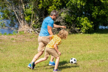 dad and son playing football during their childhood. Childhood memories of son and his dad. dad have fun with his son. journey of fatherhood. dad and son enjoying childhood adventures outdoor.