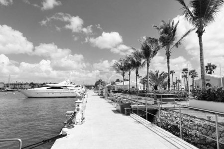 Yachthafen mit Steg und Palmen. Sommerjacht im Hafen mit Pier. Foto vom Hafen mit Anlegestelle und angedockter Jacht. Yachthafen mit Pier.