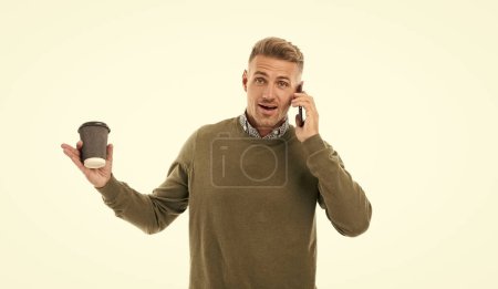 photo of amazed man has call at coffee break. man has call at coffee break isolated on white. man has call at coffee break in studio. man has call at coffee break on background.