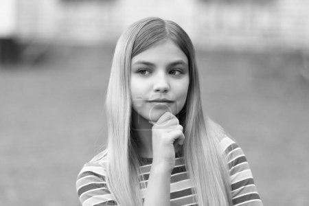 portrait of pondering teen girl with blonde hair. portrait of teen girl outdoor. portrait photo of teen girl outside. portrait of teen girl.