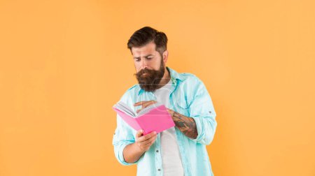 Photo for Busy hipster guy reading notebook on yellow background, erudition. - Royalty Free Image