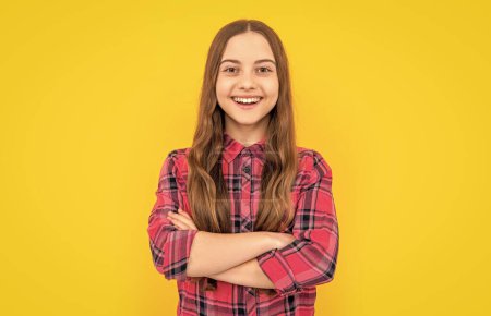 happy teen girl on background. photo of teen girl with long hair wearing checkered shirt. teen girl isolated on yellow. teen girl in studio.